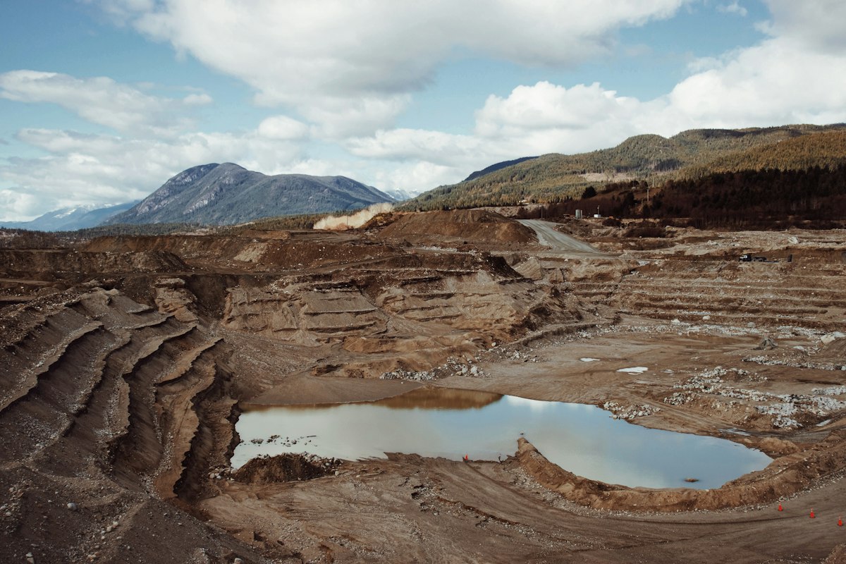 Aerial view of an open-pit mine with mountains beyond