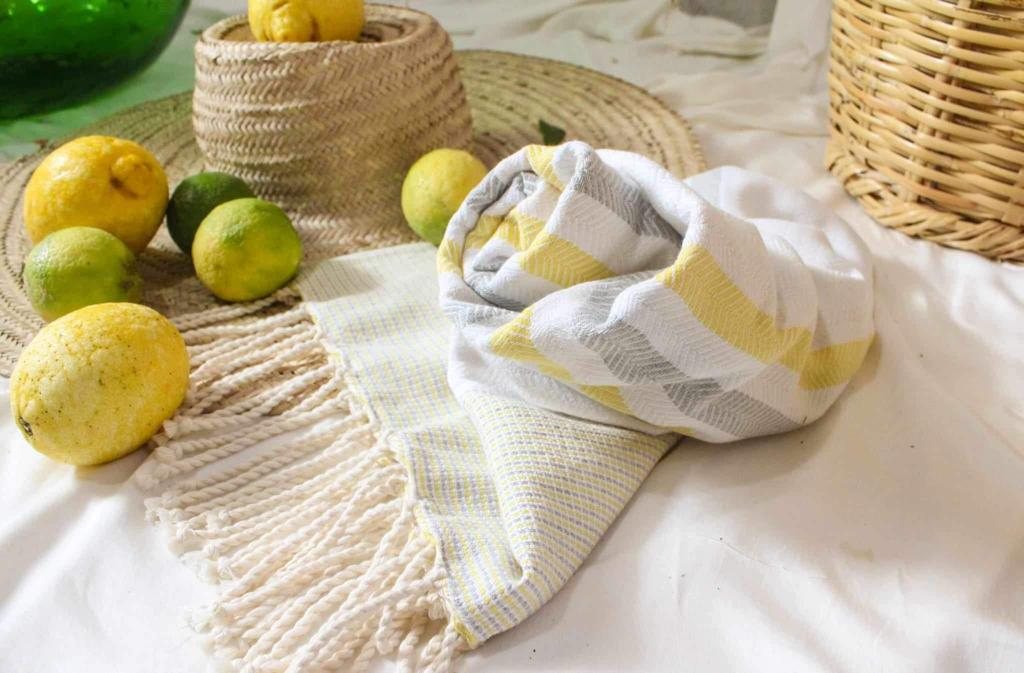 A yellow and grey fouta with lemons and woven baskets